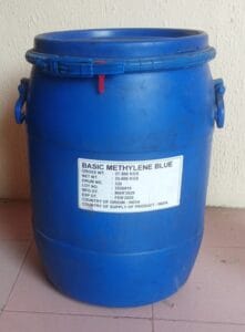 Blue plastic drum used for chemical storage with a label reading 'Basic Methylene Blue'.