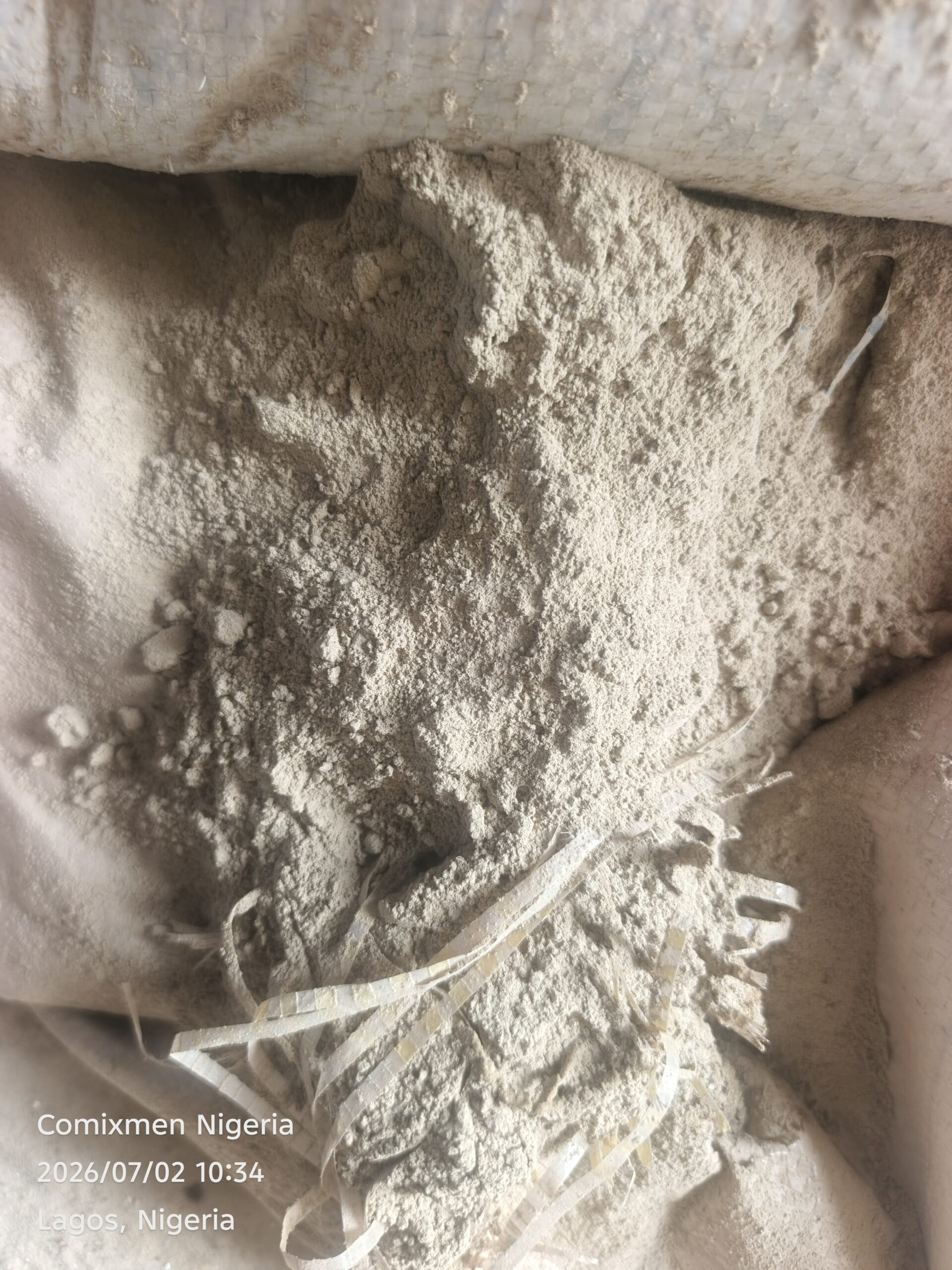 0-3048x4064-1-0-{}-0-12# Pile of light gray powder spilling from a torn bag, with shredded plastic strips nearby; label shows Comixmen Nigeria and Lagos, Nigeria.